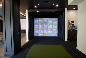 A room with a green carpet and a screen on the wall at The Crest at South Point Apartments, Davenport  30253